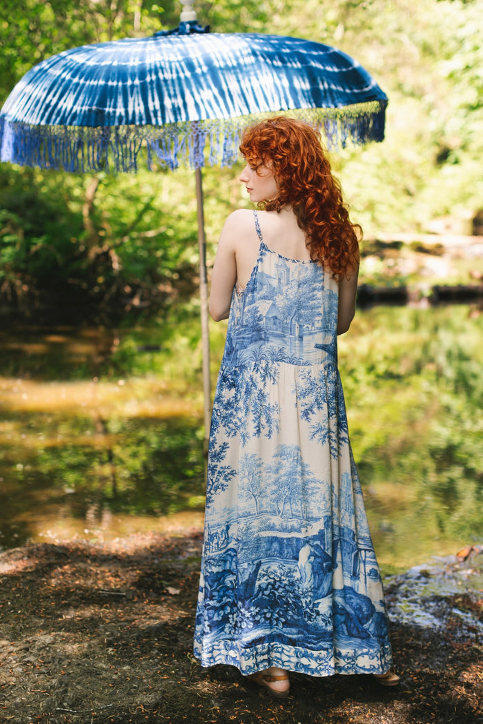 Model wearing Let the Light In bamboo viscose slip dress featuring print of Delft blue and white landscape pottery, and positive message of light and hope - Market of Stars