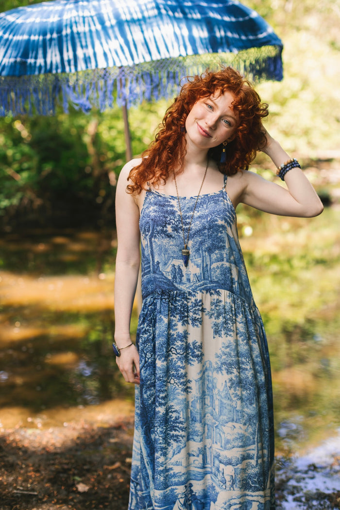 Model wearing Let the Light In bamboo viscose slip dress featuring print of Delft blue and white landscape pottery, and positive message of light and hope - Market of Stars