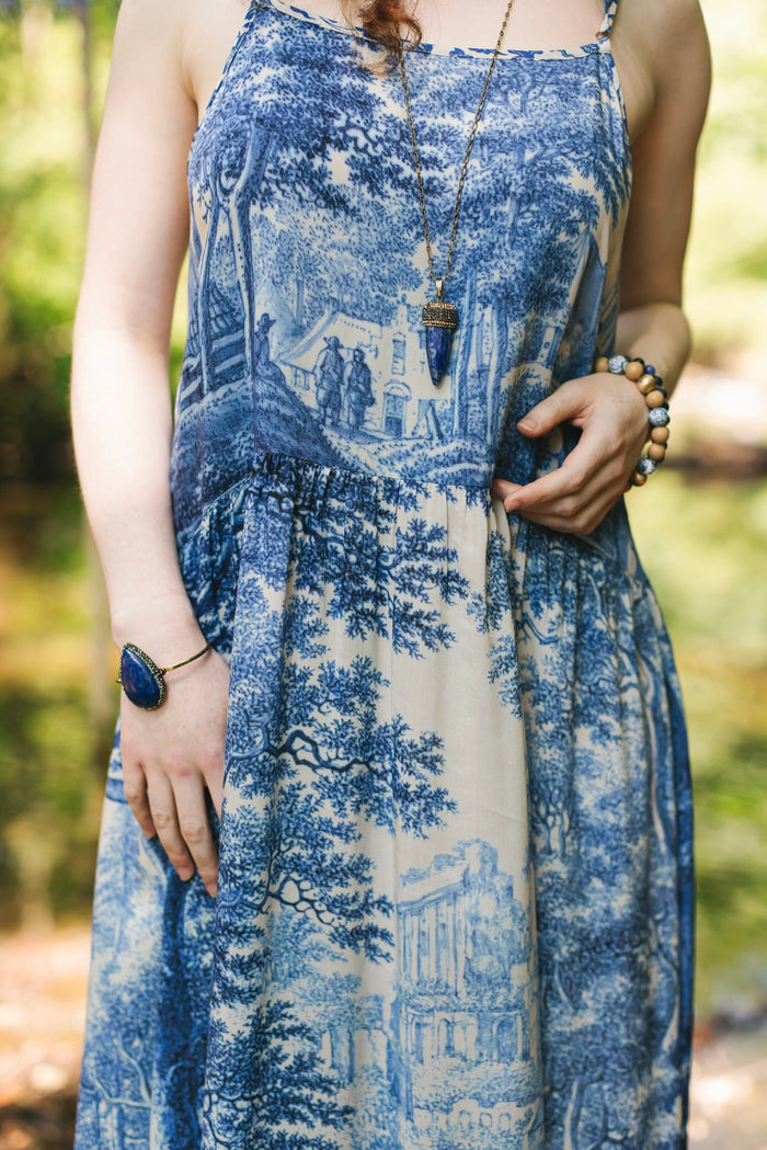 Model wearing Let the Light In bamboo viscose slip dress featuring print of Delft blue and white landscape pottery, and positive message of light and hope - Market of Stars