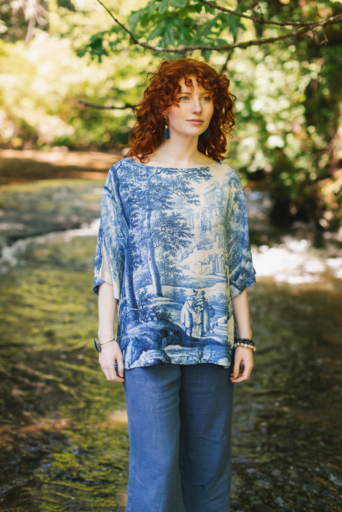 Model wearing Let the Light In bamboo viscose Luxe Tee shirt featuring print of Delft blue and white landscape pottery, and positive message of light and hope - Market of Stars
