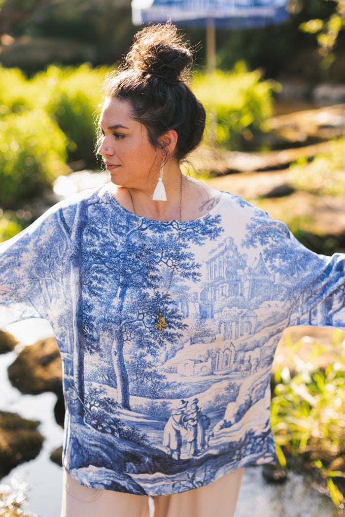 Model wearing Let the Light In bamboo viscose Luxe Tee shirt featuring print of Delft blue and white landscape pottery, and positive message of light and hope - Market of Stars