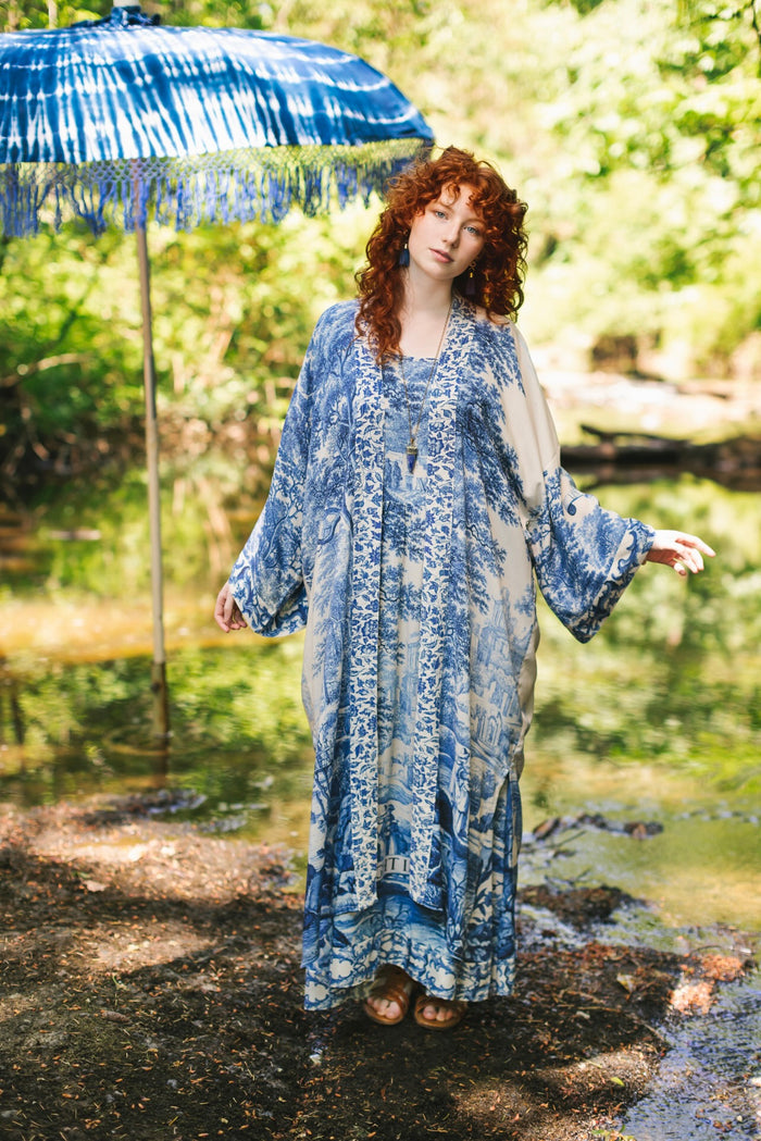 Model wearing Let the Light In long opera duster kimono featuring print of Delft blue and white landscape pottery, and positive message of light and hope - Market of Stars