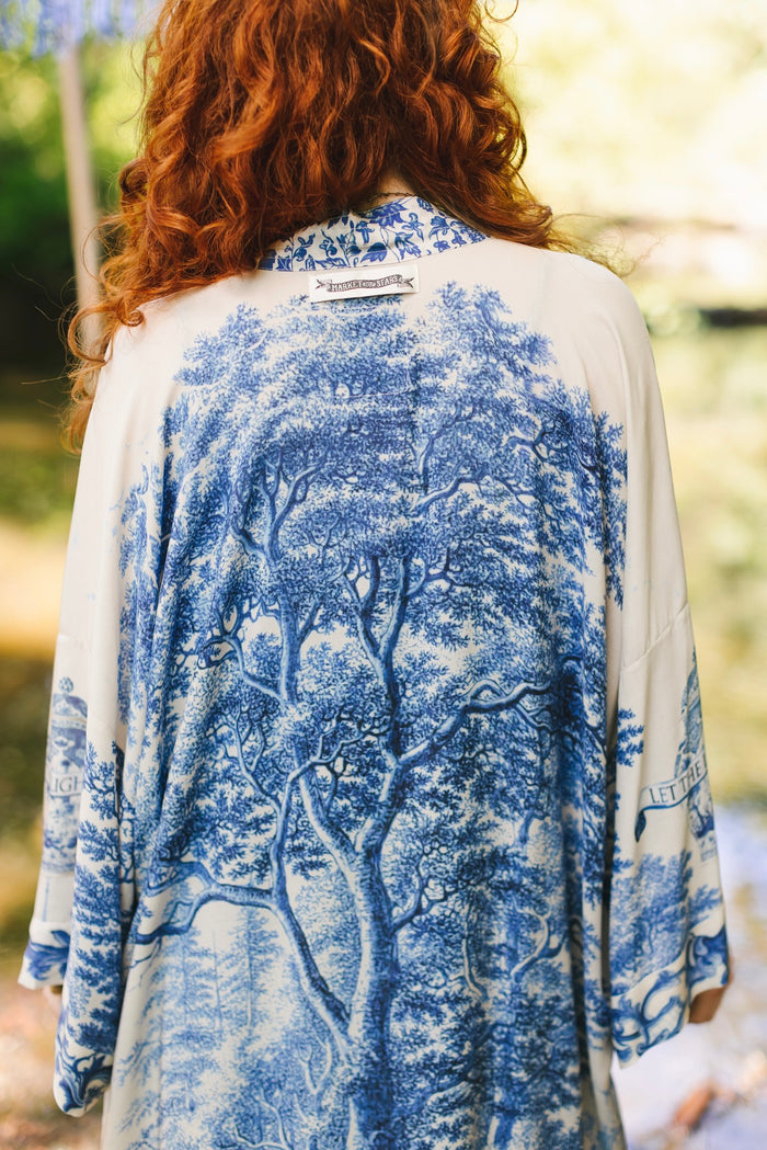 Model wearing Let the Light In long opera duster kimono featuring print of Delft blue and white landscape pottery, and positive message of light and hope - Market of Stars