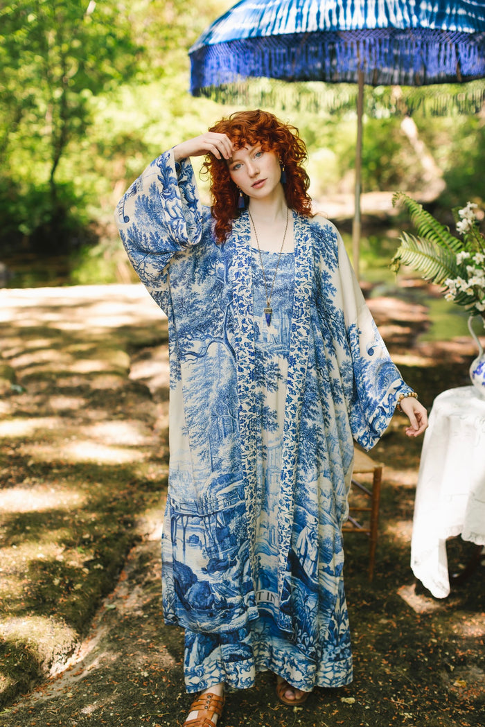 Model wearing Let the Light In long opera duster kimono featuring print of Delft blue and white landscape pottery, and positive message of light and hope - Market of Stars