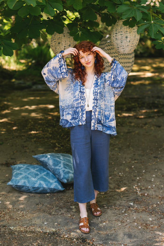 Model wearing Let the Light In cropped Pixie duster featuring print of Delft blue and white landscape pottery, and positive message of light and hope - Market of Stars