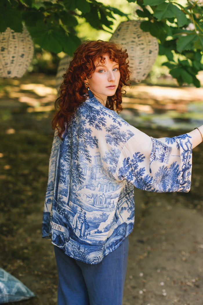 Model wearing Let the Light In cropped Pixie duster featuring print of Delft blue and white landscape pottery, and positive message of light and hope - Market of Stars