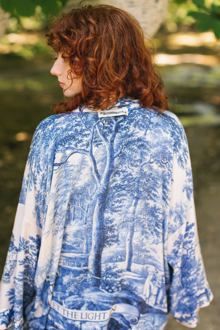 Model wearing Let the Light In cropped Pixie duster featuring print of Delft blue and white landscape pottery, and positive message of light and hope - Market of Stars
