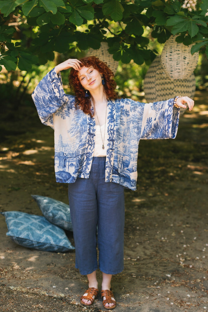 Model wearing Let the Light In cropped Pixie duster featuring print of Delft blue and white landscape pottery, and positive message of light and hope - Market of Stars