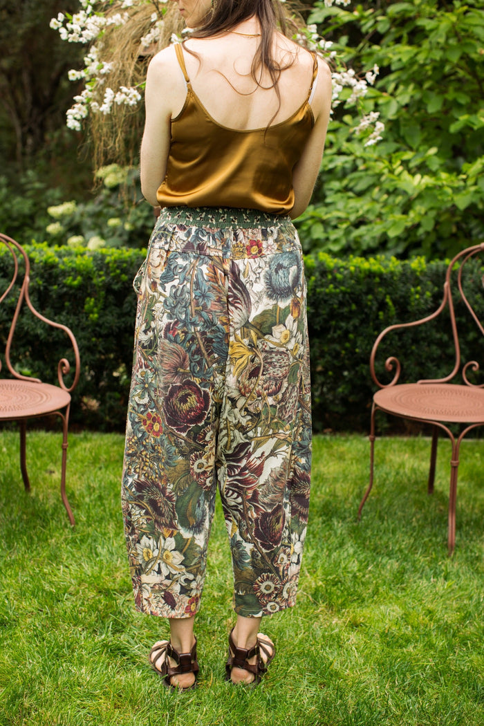 Model styled in Love Grows Wild Artist Pants featuring 1700s hand-coloured floral etchings and bumblebee trim – relaxed lantern hem and cropped fit – Market of Stars