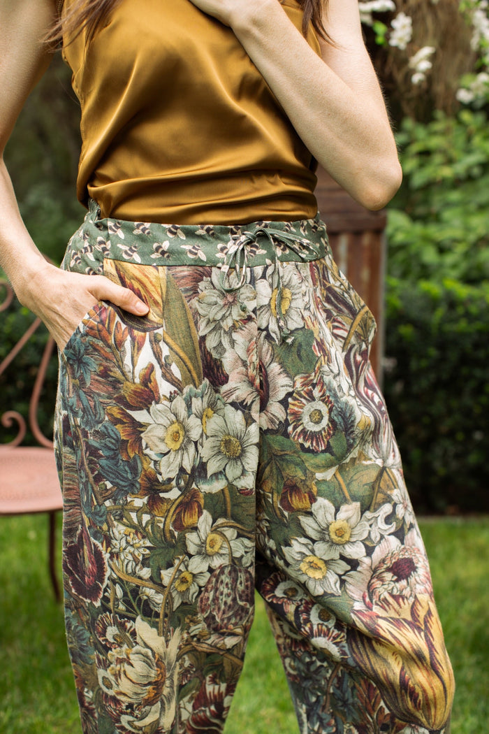Model styled in Love Grows Wild Artist Pants featuring 1700s hand-coloured floral etchings and bumblebee trim – relaxed lantern hem and cropped fit – Market of Stars