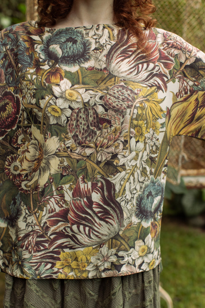 Model wearing the Love Grows Wild Luxe Tee featuring lush floral etchings inspired by 1700s botanical art with hidden bee trim detail – Market of Stars.