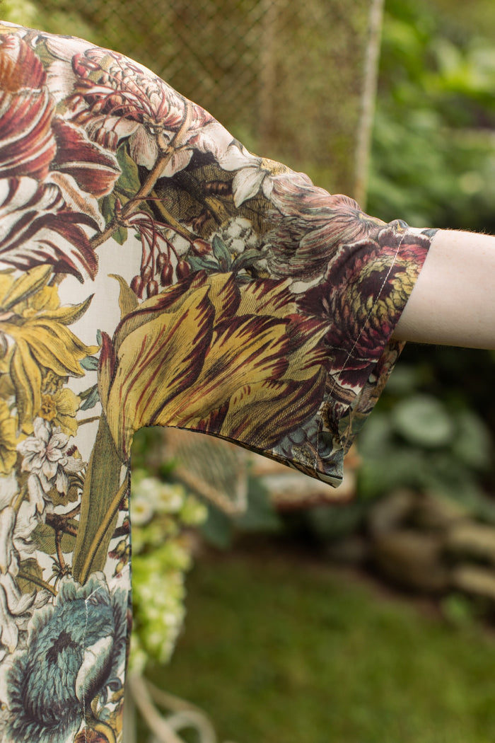 Model wearing the Love Grows Wild Luxe Tee featuring lush floral etchings inspired by 1700s botanical art with hidden bee trim detail – Market of Stars.