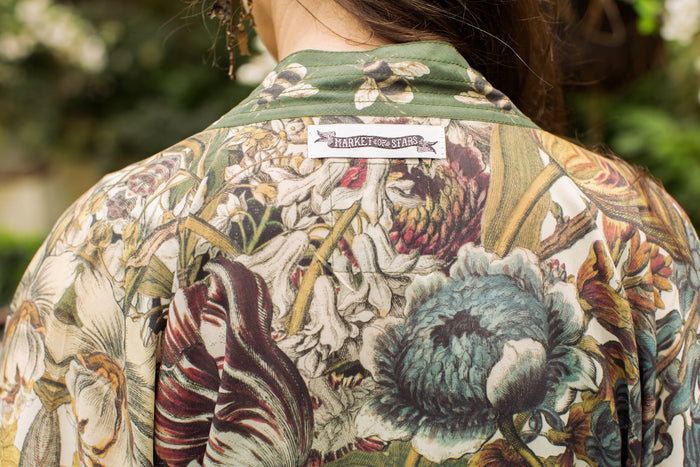 Model wearing Love Grows Wild Pixie Duster featuring hand-coloured 1700s floral etchings and charming bumblebee trim, celebrating the joy of abundance – Market of Stars.