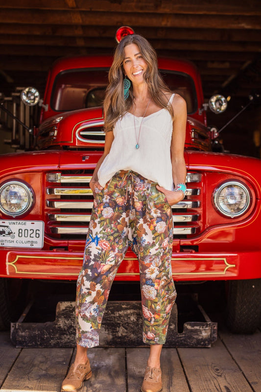 Model wearing linen blend artist pants with 1854 floral art, heart-in-hand symbol, and “Love one another” handwritten script – Market of Stars.