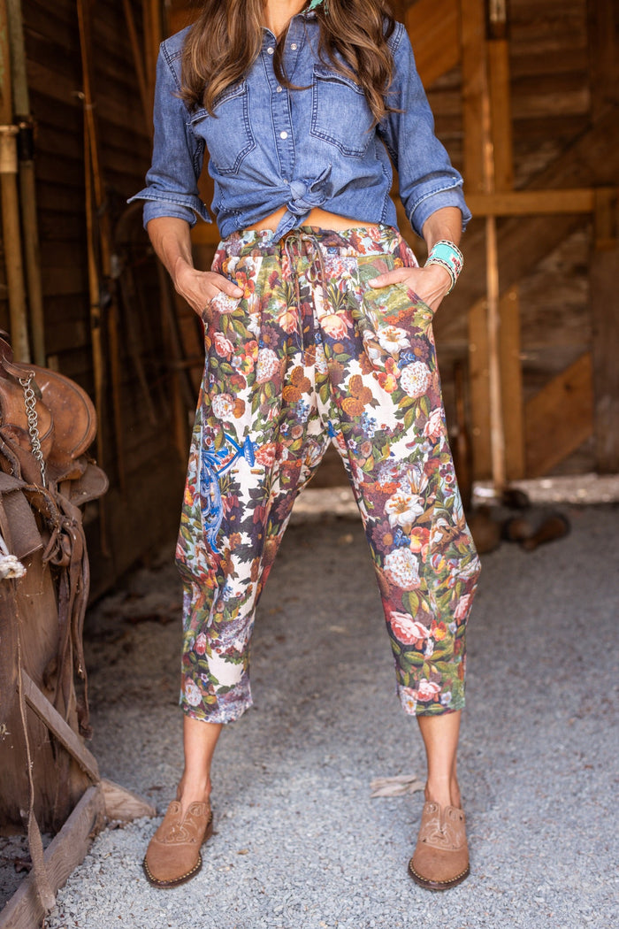 Model wearing linen blend artist pants with 1854 floral art, heart-in-hand symbol, and “Love one another” handwritten script – Market of Stars.