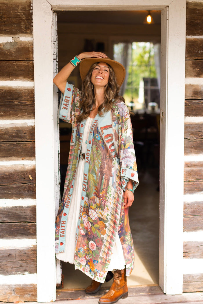 Model wearing romantic full-length kimono featuring joyful 1854 floral art, heart-in-hand symbol, and handwritten messages of love – Market of Stars
