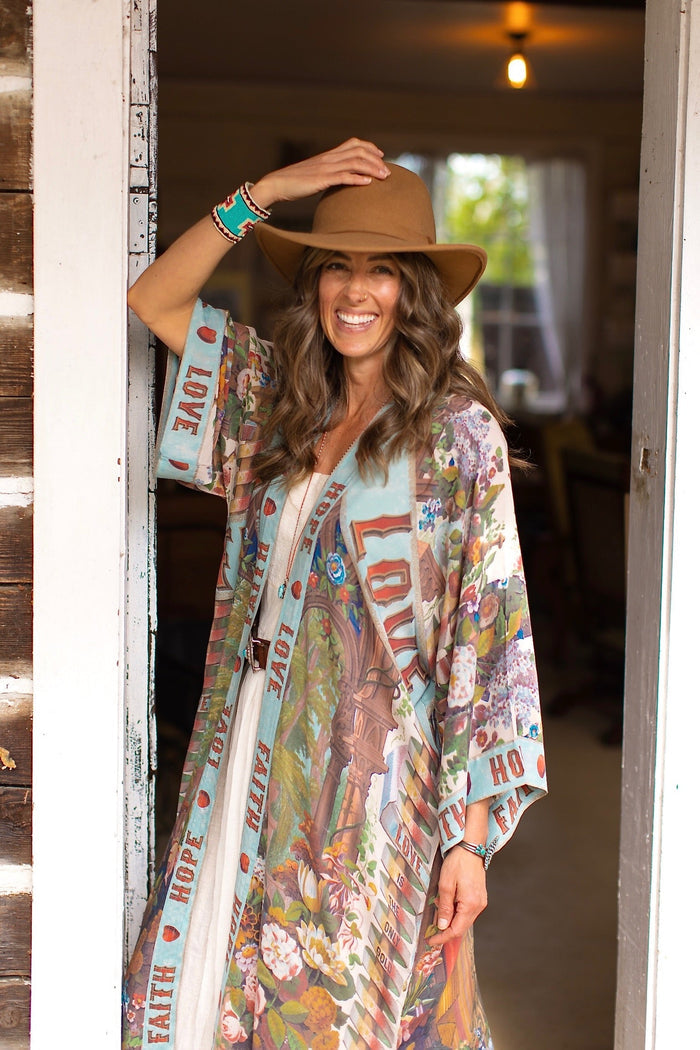 Model wearing romantic full-length kimono featuring joyful 1854 floral art, heart-in-hand symbol, and handwritten messages of love – Market of Stars