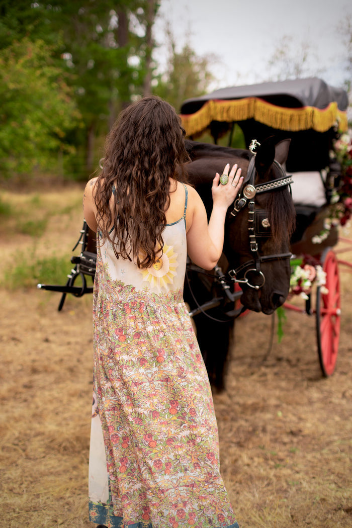 Model wearing a maxi-length slip dress ft. a woman astride a rearing horse, soft vintage florals, rosettes and lithographs from the 1800's - Market of Stars