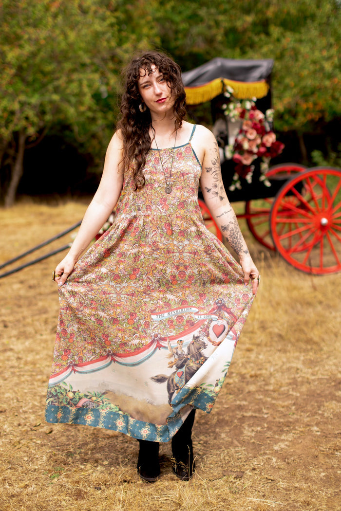 Model wearing a maxi-length slip dress ft. a woman astride a rearing horse, soft vintage florals, rosettes and lithographs from the 1800's - Market of Stars