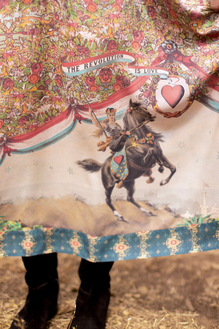 Model wearing a maxi-length slip dress ft. a woman astride a rearing horse, soft vintage florals, rosettes and lithographs from the 1800's - Market of Stars