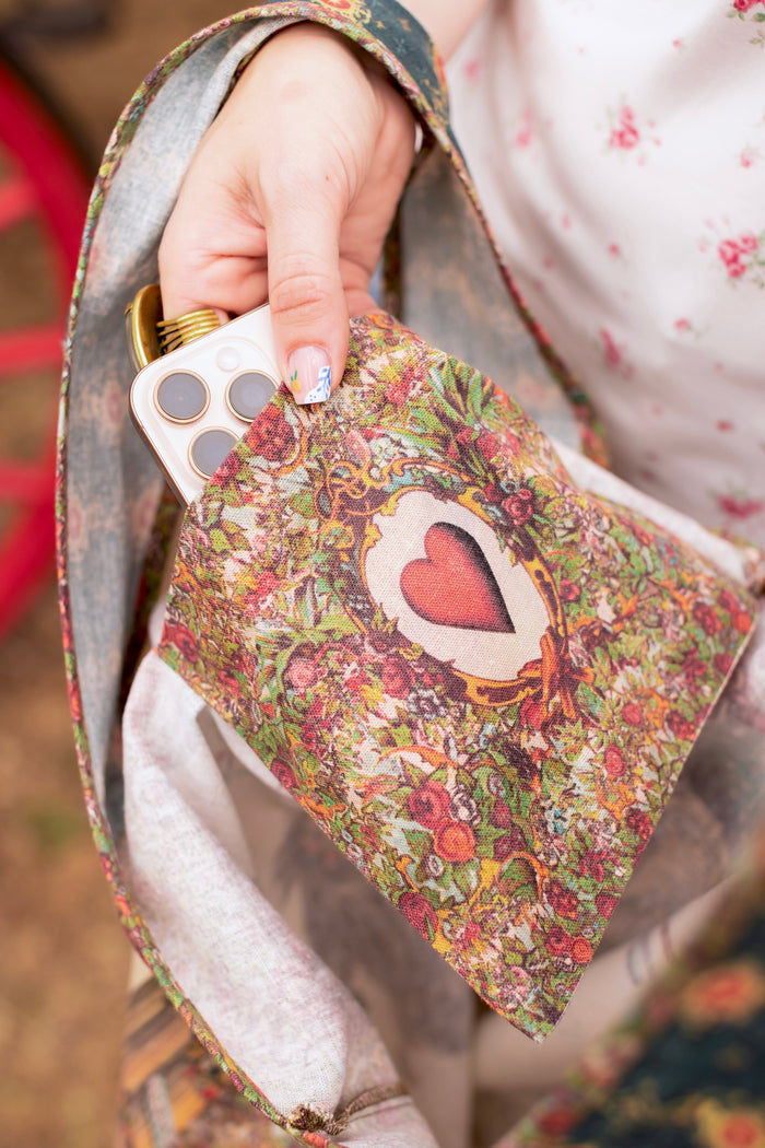 Model carrying a linen tote bag ft. a woman astride a rearing horse, soft vintage florals, rosettes and lithographs from the 1800's - Market of Stars