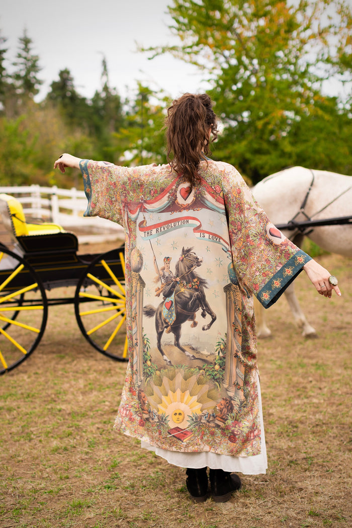 Model wearing a full-length duster ft. a woman astride a rearing horse, soft vintage florals, rosettes and lithographs from the 1800's - Market of Stars