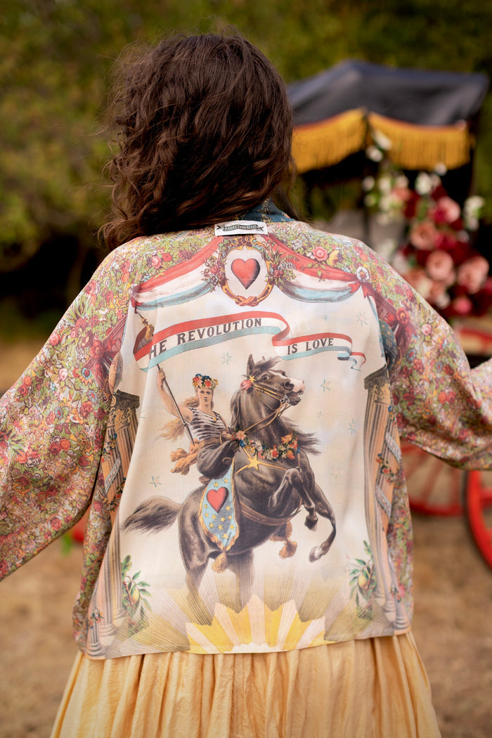 Model wearing cropped length duster ft. a woman astride a rearing horse, soft vintage florals, rosettes and lithographs from the 1800's - Market of Stars