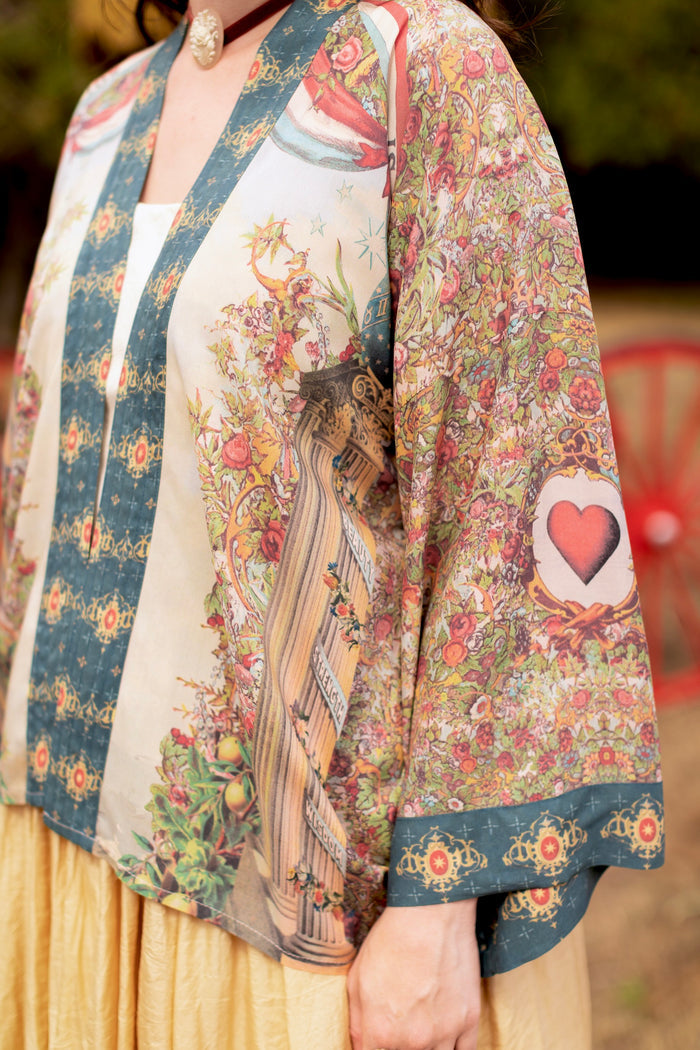 Model wearing cropped length duster ft. a woman astride a rearing horse, soft vintage florals, rosettes and lithographs from the 1800's - Market of Stars