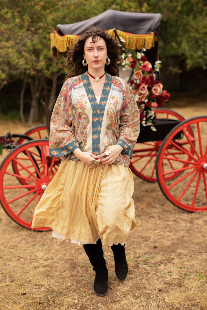 Model wearing cropped length duster ft. a woman astride a rearing horse, soft vintage florals, rosettes and lithographs from the 1800's - Market of Stars