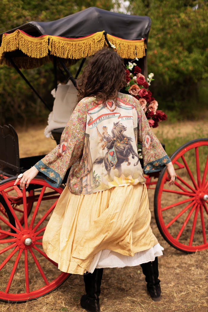 Model wearing cropped length duster ft. a woman astride a rearing horse, soft vintage florals, rosettes and lithographs from the 1800's - Market of Stars