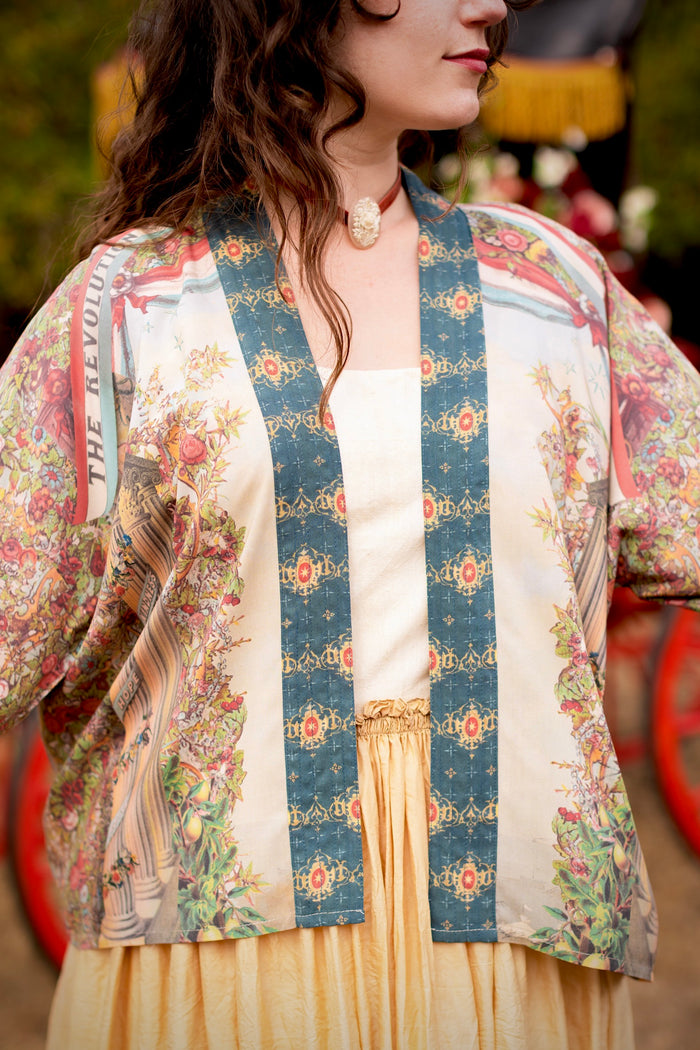 Model wearing cropped length duster ft. a woman astride a rearing horse, soft vintage florals, rosettes and lithographs from the 1800's - Market of Stars