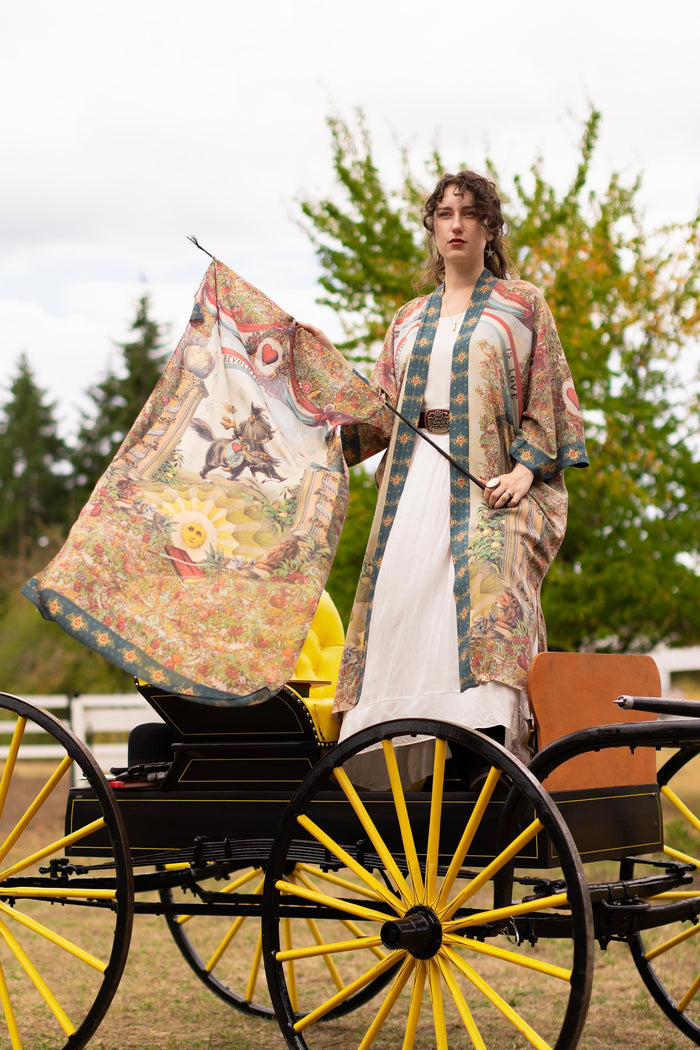 Model wearing a bamboo-viscose scarf ft. a woman astride a rearing horse, soft vintage florals, rosettes and lithographs from the 1800's - Market of Stars