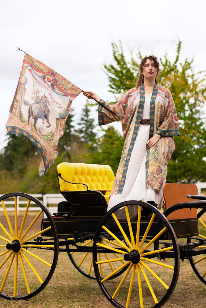 Model wearing a bamboo-viscose scarf ft. a woman astride a rearing horse, soft vintage florals, rosettes and lithographs from the 1800's - Market of Stars
