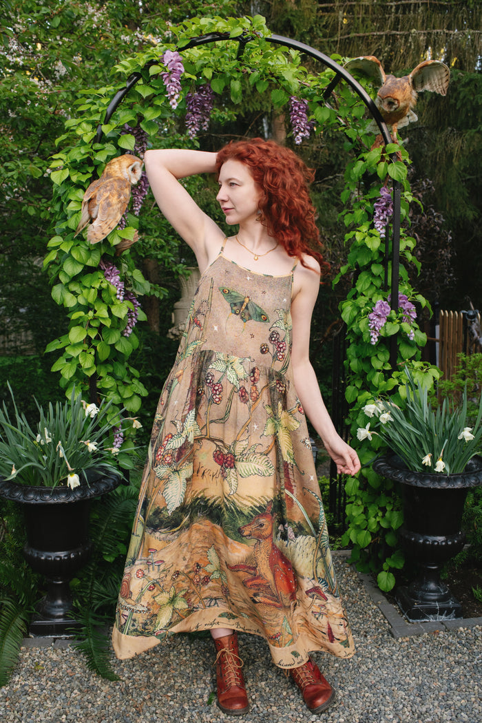 Model wearing an enchanting maxi-length slip dress featuring illustrations by Charles van Sandwyk, crafted from airy bamboo-based viscose with a touch of whimsical magic - Market of Stars