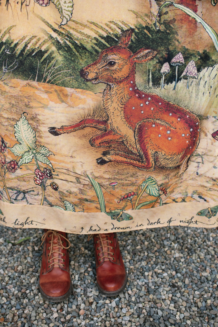 Model wearing an enchanting maxi-length slip dress featuring illustrations by Charles van Sandwyk, crafted from airy bamboo-based viscose with a touch of whimsical magic - Market of Stars