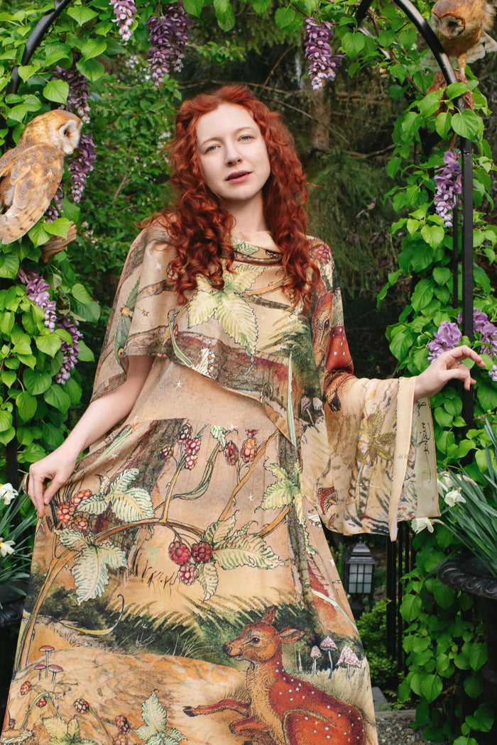 Model wearing an enchanting maxi-length slip dress featuring illustrations by Charles van Sandwyk, crafted from airy bamboo-based viscose with a touch of whimsical magic - Market of Stars