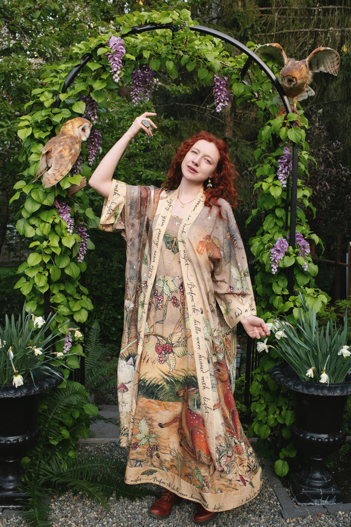 Model wearing an enchanting maxi-length slip dress featuring illustrations by Charles van Sandwyk, crafted from airy bamboo-based viscose with a touch of whimsical magic - Market of Stars