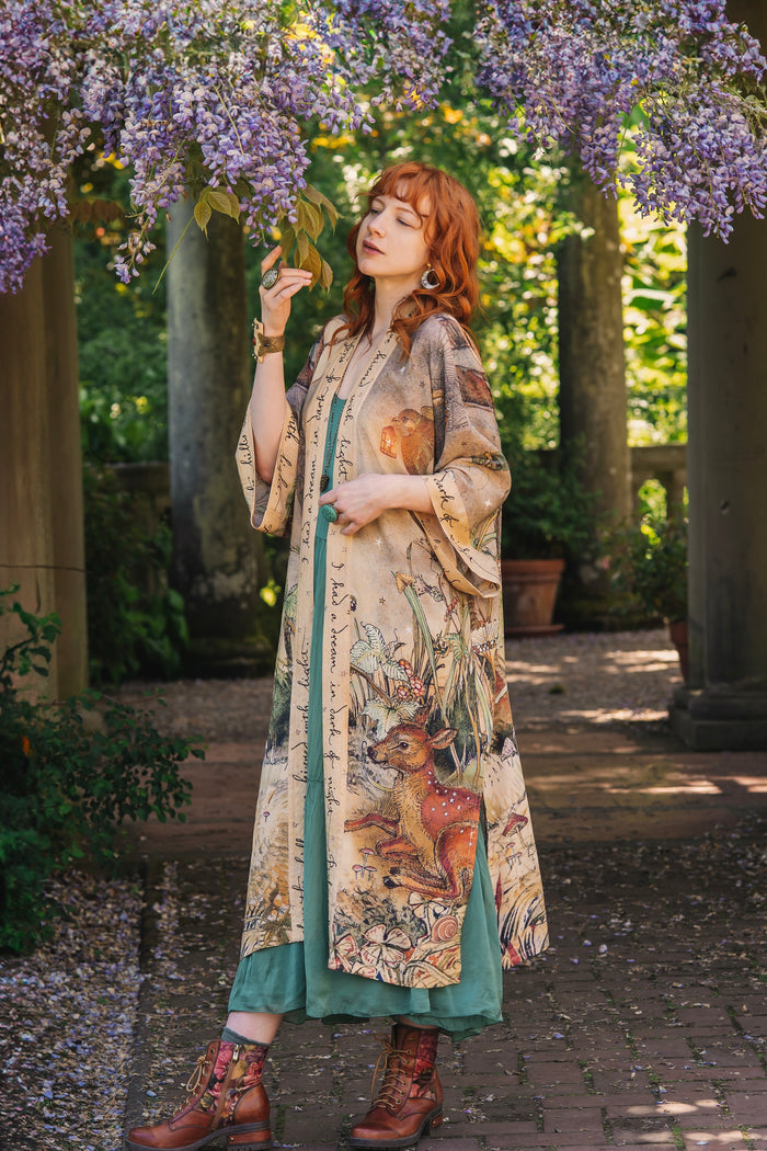 Model wearing an enchanting kimono duster robe featuring illustrations by Charles van Sandwyck's, crafted from airy bamboo-based viscose with a touch of whimsical magic - Market of Stars
