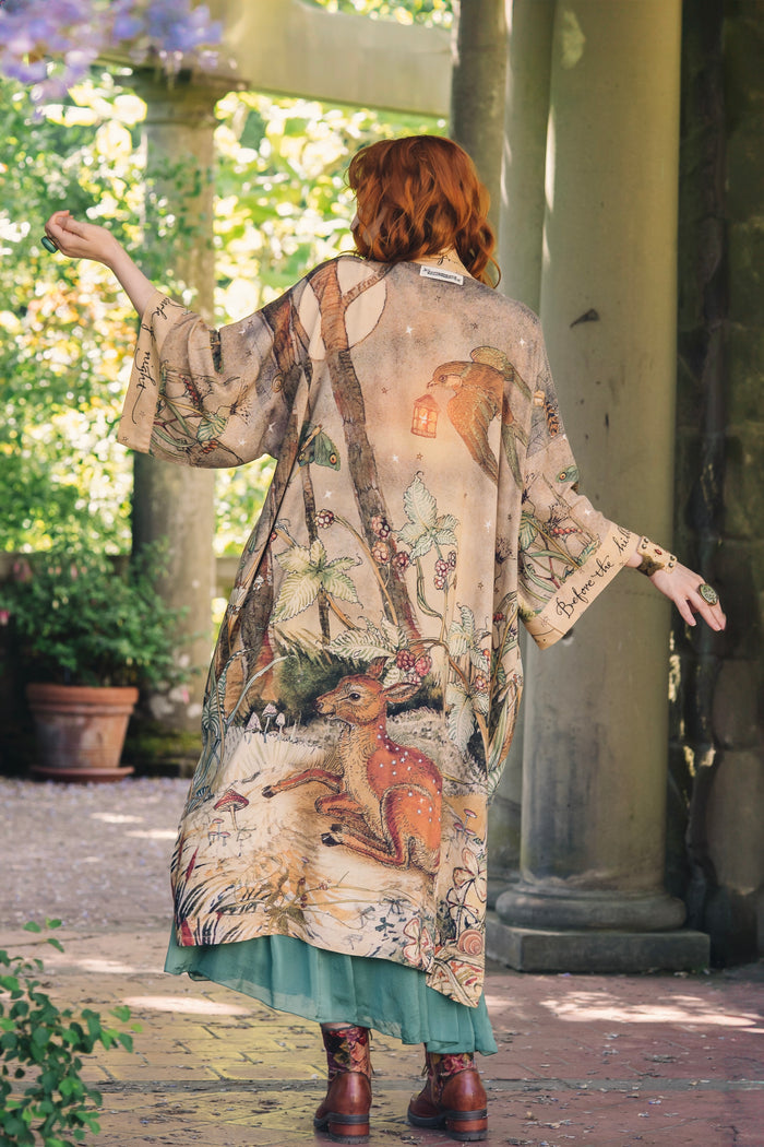 Model wearing an enchanting kimono duster robe featuring illustrations by Charles van Sandwyck's, crafted from airy bamboo-based viscose with a touch of whimsical magic - Market of Stars