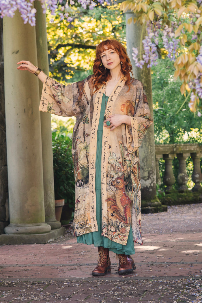 Model wearing an enchanting kimono duster robe featuring illustrations by Charles van Sandwyck's, crafted from airy bamboo-based viscose with a touch of whimsical magic - Market of Stars