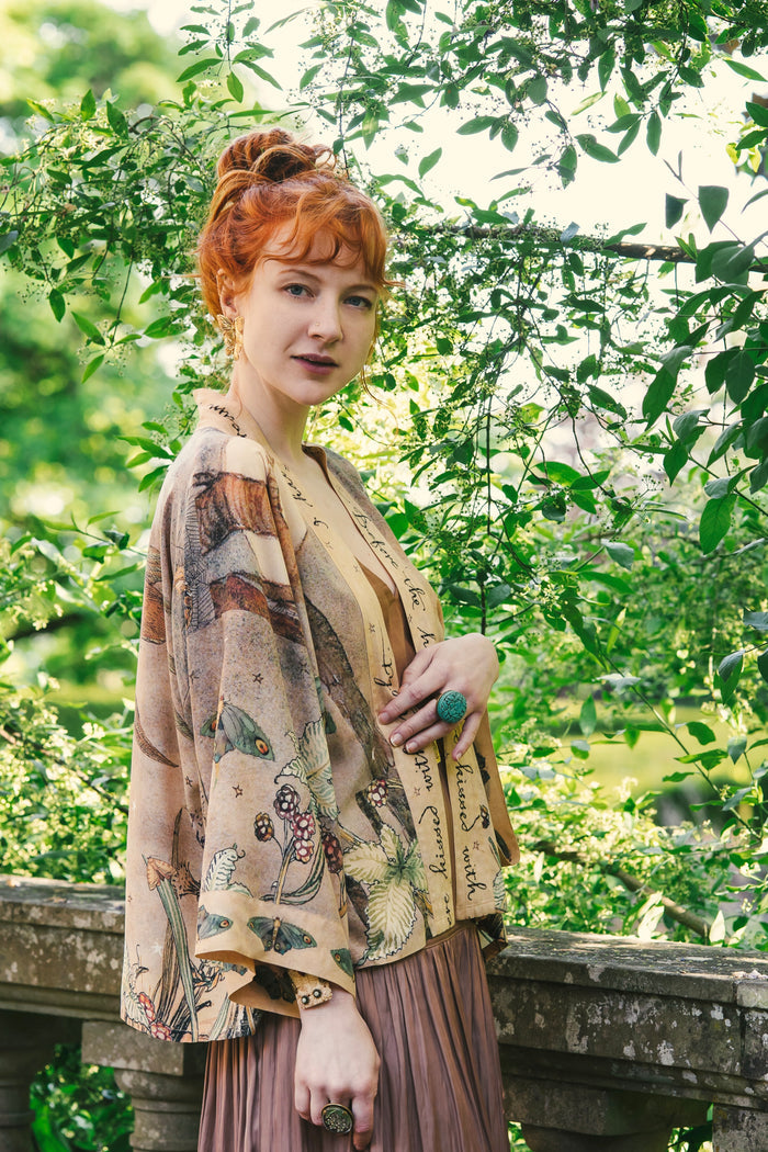 Model wearing an enchanting cropped kimono duster featuring illustrations by Charles van Sandwyck's, crafted from airy bamboo-based viscose with a touch of whimsical magic - Market of Stars
