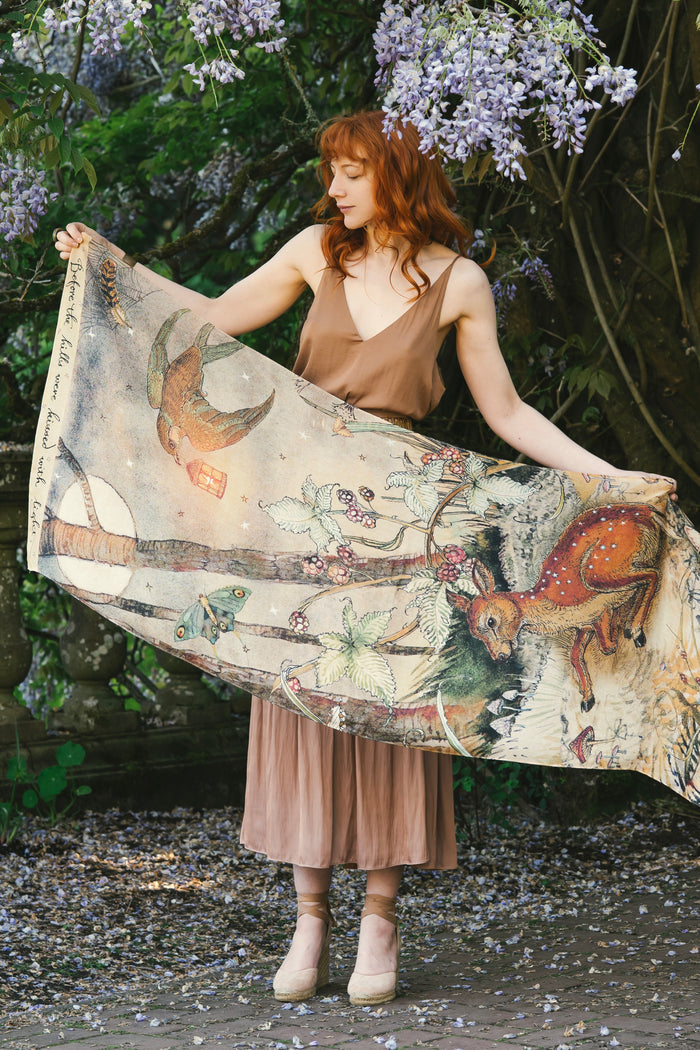 Model wearing an enchanting scarf featuring Charles van Sandwyck's illustrations, crafted from airy bamboo-based viscose with a touch of whimsical magic - Market of Stars