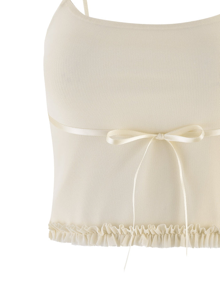 A close-up of the TIGERMIST MAISIE TOP in pale yellow, a cream-colored sleeveless crop top with adjustable straps, satin bow at the front, and frill detail along the hem.