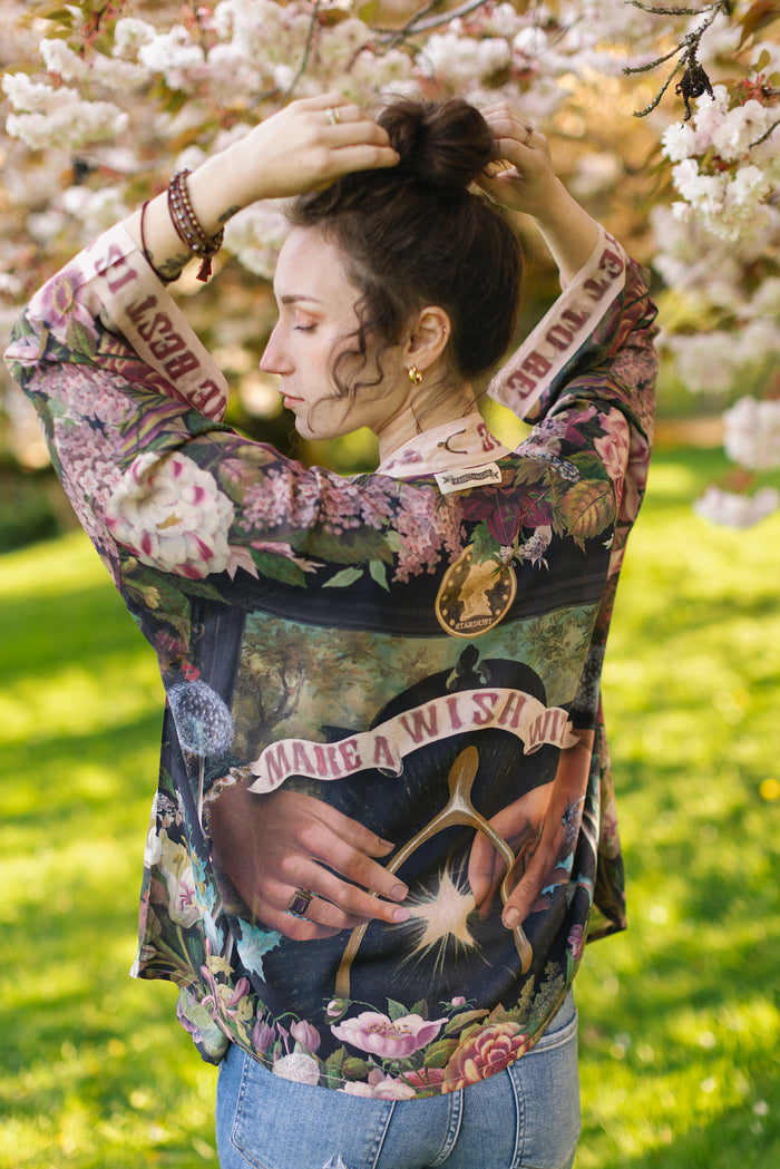 Model wearing cropped kimono featuring gold wishbone–vintage coin–evening star–dandelion–and spring floral collage with “Make a wish” banner – Market of Stars
