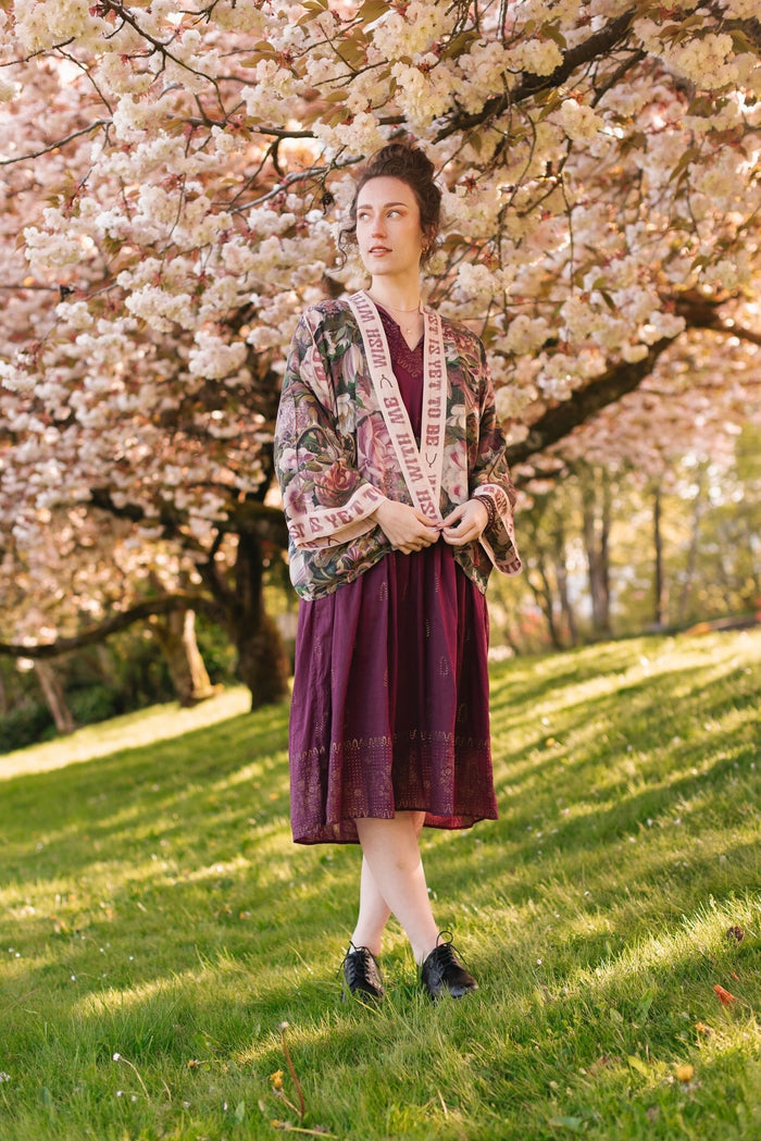 Model wearing cropped kimono featuring gold wishbone–vintage coin–evening star–dandelion–and spring floral collage with “Make a wish” banner – Market of Stars