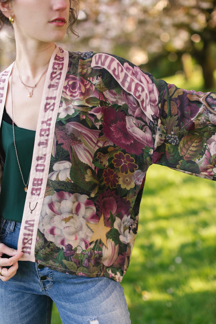 Model wearing cropped kimono featuring gold wishbone–vintage coin–evening star–dandelion–and spring floral collage with “Make a wish” banner – Market of Stars