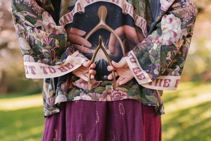 Model wearing cropped kimono featuring gold wishbone–vintage coin–evening star–dandelion–and spring floral collage with “Make a wish” banner – Market of Stars