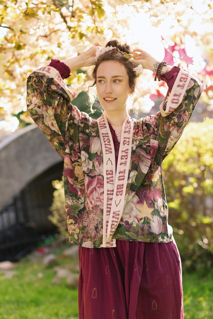 Model wearing cropped kimono featuring gold wishbone–vintage coin–evening star–dandelion–and spring floral collage with “Make a wish” banner – Market of Stars