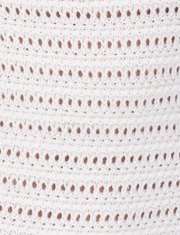 Close-up of the TIGERMIST MARLEIGH DRESS - WHITE featuring rows of evenly spaced, small oval holes. The texture and intricacy of the stitches are clearly visible, highlighting the delicate and detailed craftsmanship typical of a maxi length dress.