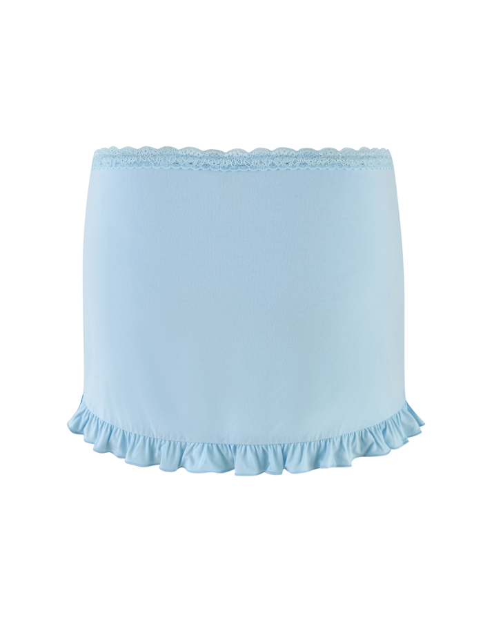 The TIGERMIST MELLIE SKORT - BLUE in baby blue features a buttery jersey fabric, tonal lace waistband, and ruffled hem, shown against a white background.